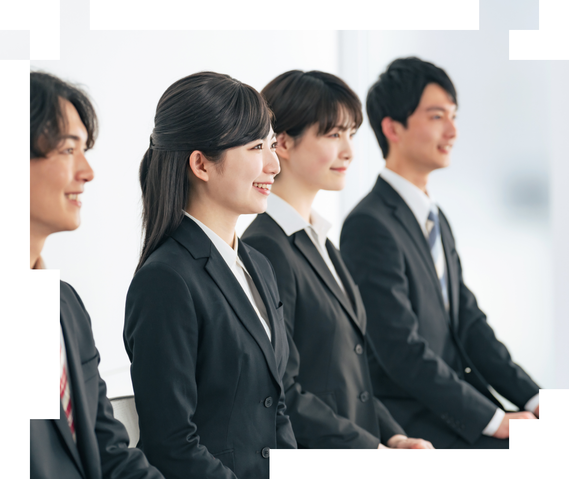 黒いスーツを着た若手ビジネスパーソンが横一列に並び、前方を見つめている様子。女性と男性が微笑みながら並んでいる。新卒採用や企業説明会のイメージ